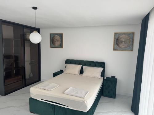 a bedroom with a bed with a green headboard at AD Home in Bar