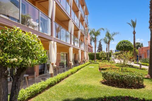 a building with a lawn in front of it at Savoy Le Grand Hotel Marrakech in Marrakech