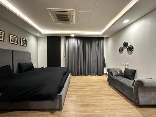 a bedroom with a bed and a couch at Luxury Apartments at Goldcrest Mall and Residency DHA Phase 4 by Nirvana Nests in Lahore
