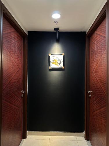 a hallway with two doors and a picture on the wall at Luxury Apartments at Goldcrest Mall and Residency DHA Phase 4 by Nirvana Nests in Lahore