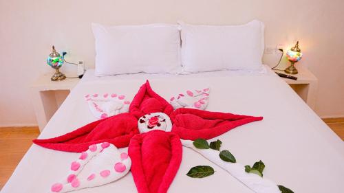 a bed with red towels and pillows on it at Les Jardins d Amizmiz 6 piscines in Marrakech