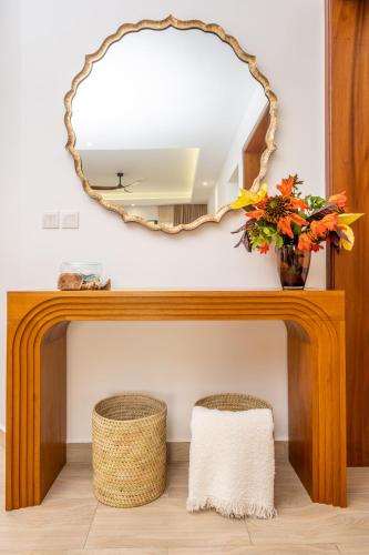 a mirror and two stools in front of a table at Sandcastle 2 Apartment in Galu