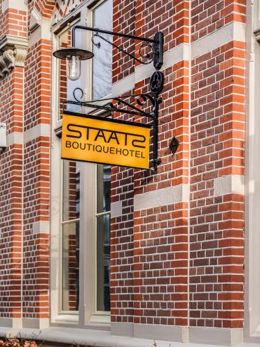 a sign on the side of a brick building at Boutiquehotel Staats in Haarlem