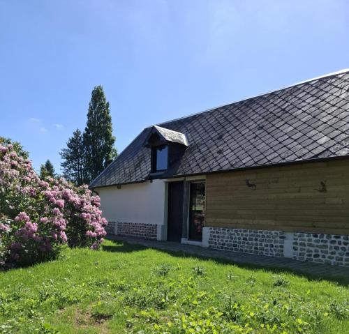 a house with pink flowers in the yard at La gîte "Ressources" au calme avec jardin et jacuzzi entre Rouen et Le Havre in La Frenaye