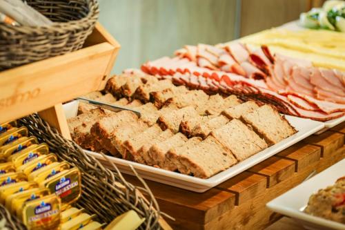 a display of bread and other foods on a table at Omega Hotel in Olsztyn