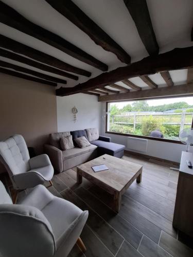 a living room with a couch and a coffee table at La gîte "Ressources" au calme avec jardin et jacuzzi entre Rouen et Le Havre in La Frenaye