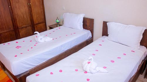 two beds with hearts and stuffed swans on them at Les Jardins d Amizmiz 6 piscines in Marrakech