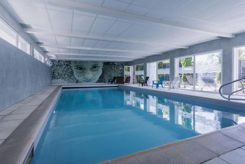 uma grande piscina com uma máscara na parede em BRIT HOTEL - RESTAURANT Saint-Brieuc Langueux em Langueux