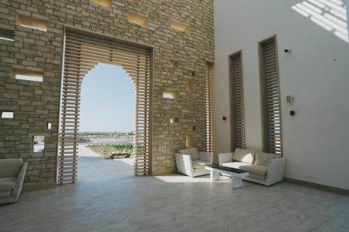 a living room with chairs and a brick wall at Sentido Reef Oasis Suakin Resort in Marsa Alam City