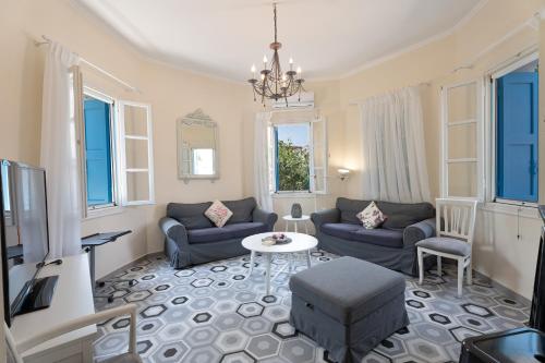 een woonkamer met twee banken en een tafel bij 1944-Heritage House in Lardos