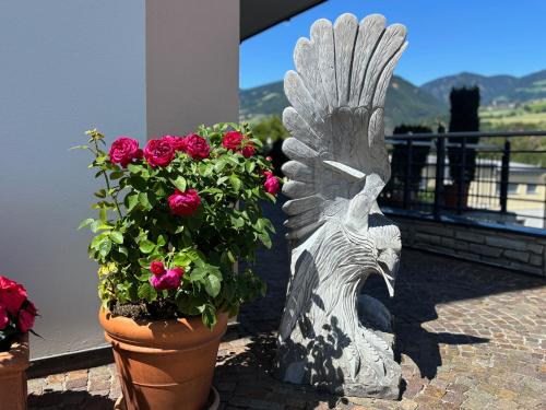 a statue of a statue of a bird with flowers at Superior Apartments Marialisa Tulpe in Chiusa