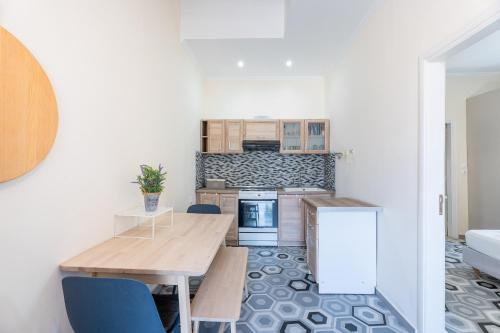 een keuken met een houten tafel en blauwe stoelen bij 1944-Heritage House in Lardos