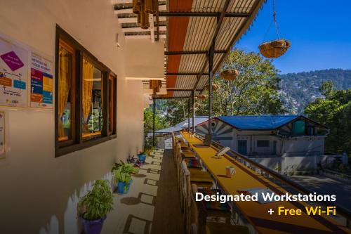 a building with a patio with tables and chairs at goSTOPS Nainital in Nainital