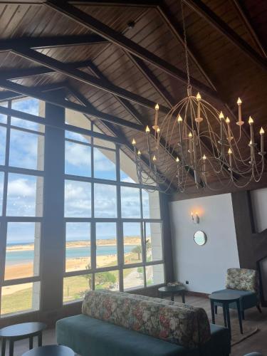 a living room with a couch and a chandelier at Hotel Milagros Golf in Mogro
