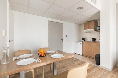 a kitchen and dining room with a table and chairs at Appart'City Confort Perpignan Centre Gare in Perpignan