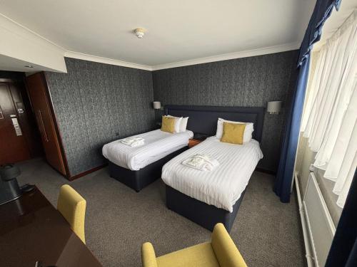 a hotel room with two beds and a chair at The Liner at Liverpool in Liverpool