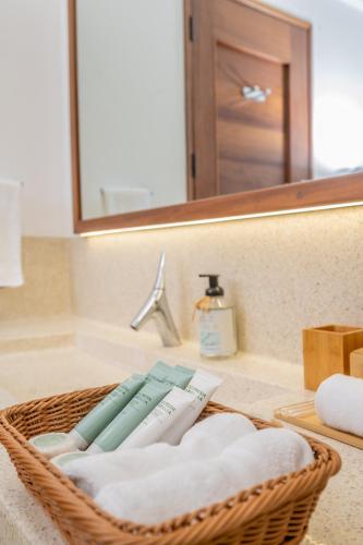 a basket of towels sitting on a bathroom sink at Sandcastle 2 Apartment in Galu