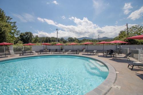 - une piscine avec des tables, des chaises et des parasols dans l'établissement Mobilhome 1 Tout Confort, à Taglio-Isolaccio