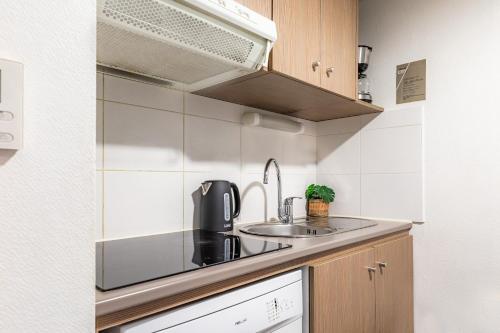 a kitchen with a sink and a microwave at Appart'City Confort Perpignan Centre Gare in Perpignan