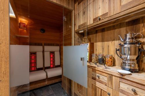 a kitchen with wooden walls and a large refrigerator at Sunstar Hotel Klosters in Klosters