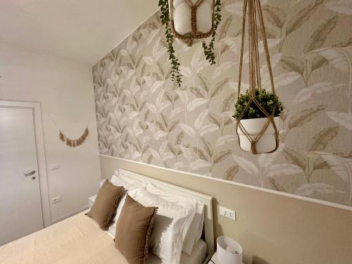 a bedroom with a bed with a plant on the wall at Domoi Property Apartment in Pisa