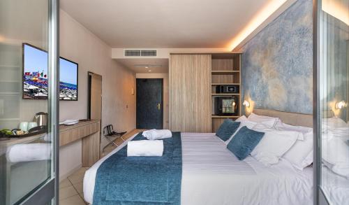 a bedroom with a large bed with a tv on the wall at Hotel Harmony-Smile in Lido di Camaiore
