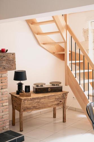 a room with a table with a stove and stairs at Ô Vieux Moulin in Duras