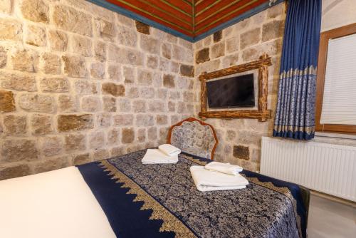 a room with a bed in a stone wall at Kayatas Cave Suites in Goreme