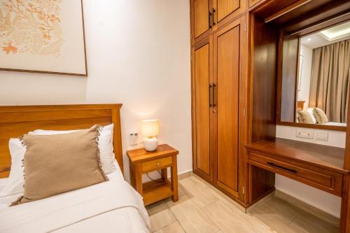 a bedroom with a bed and a dresser and a mirror at Sandcastle 2 Apartment in Galu