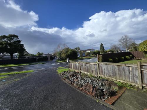 an empty street with a fence on the side of a road at Private Studio Sleepout in Aucklands Convenient Location in Auckland