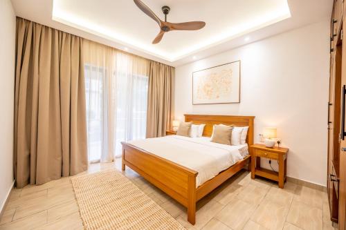 a bedroom with a bed and a ceiling fan at Sandcastle 2 Apartment in Galu