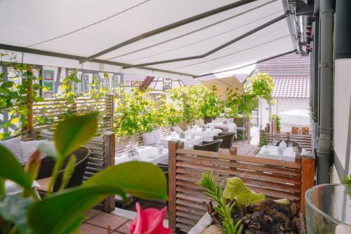 a restaurant patio with tables and chairs and plants at Hotel Restaurant Der Engel, Sasbachwalden in Sasbachwalden