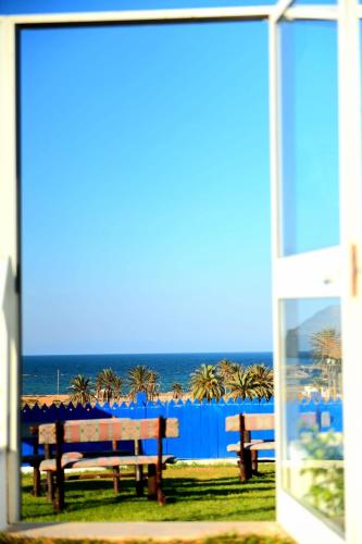 a view of the ocean from a window with benches at Pallax hotel in Zarzis