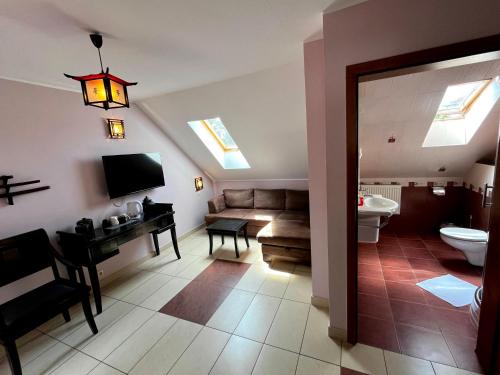 a living room with a couch and a desk and a television at Wojtecki in Pobierowo