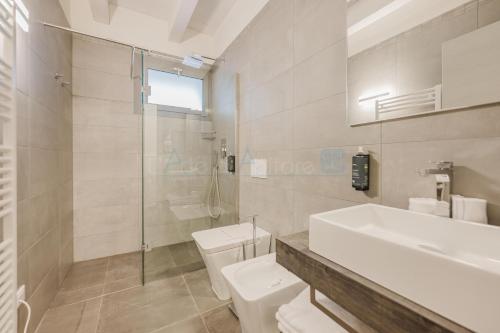 a bathroom with a sink and a toilet and a shower at Ninfea Platinum Caorle 3 in Caorle