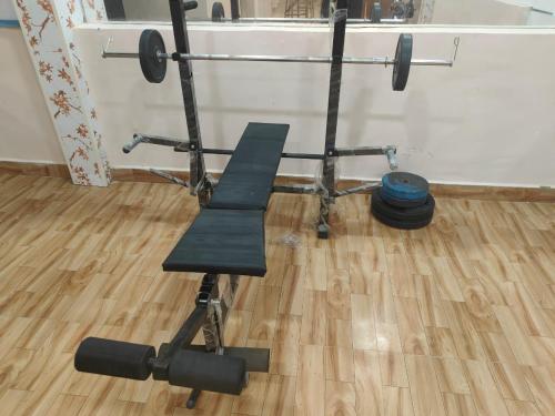 a barbell and a bench in a room at Shafi Villa in Neral