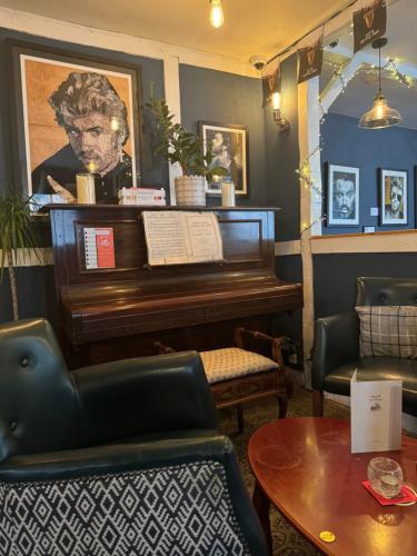 a living room with a piano and a table at The Miller of Mansfield in Goring