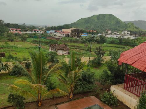 a view of a village with a palm tree at Shafi Villa in Neral