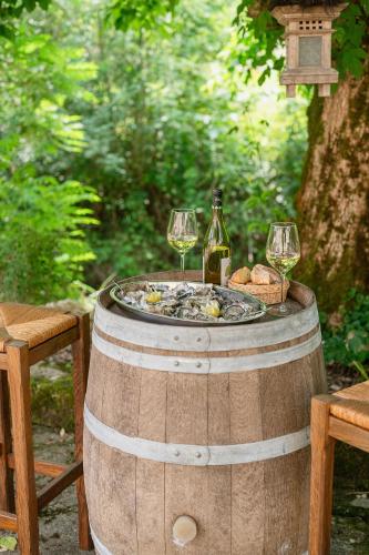 a barrel with two glasses of wine and bread at Ô Vieux Moulin in Duras