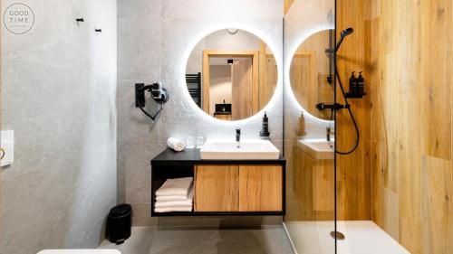シュクラルスカ・ポレンバにあるApartamenty Good Time - Zloty Horyzont Resort- Bliżej Chmurの洗面台と鏡のあるバスルーム