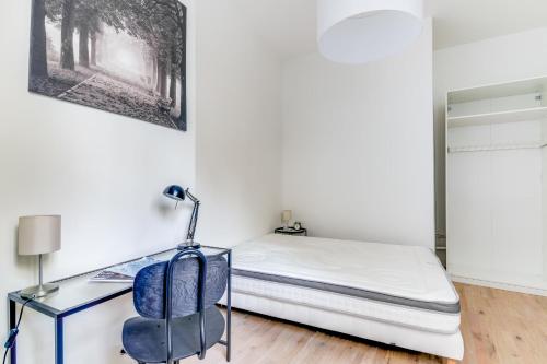 une chambre avec un lit et un bureau dans l'établissement Nice Apt In Nation !, à Paris