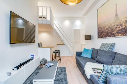 un salon avec un canapé et une télévision dans l'établissement Nice Apt In Nation !, à Paris