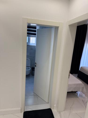 a bedroom with a white door and a bed at Mia Apartment in Golem