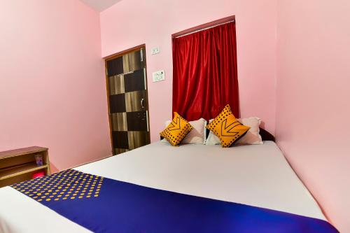 a bedroom with a bed with a red curtain at Hotel O Vivek in Hājīpur