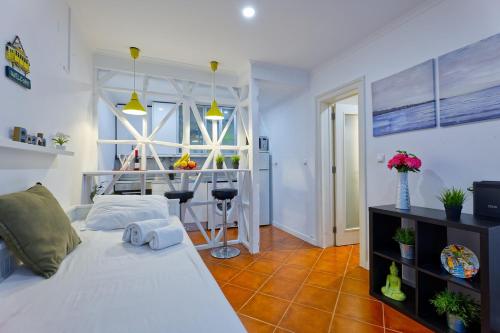 a bedroom with a white bed and a table at Cozy studio in Alfama in Lisbon