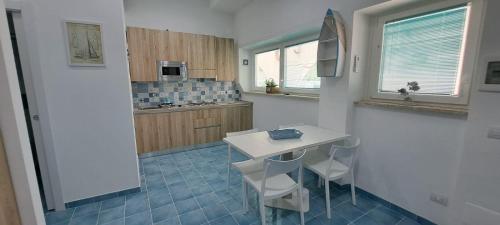 una cucina con tavolo bianco e pavimento piastrellato blu di Casa Tea San Felice Circeo a San Felice Circeo