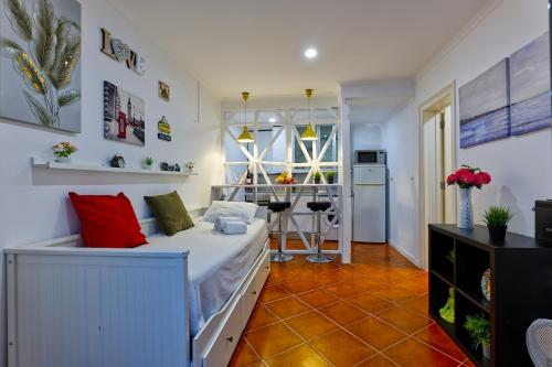 a room with a bed with red pillows on it at Cozy studio in Alfama in Lisbon