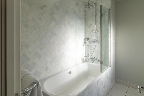 a white bath tub in a bathroom with a shower at Millbrook Lodge in Ballynahinch