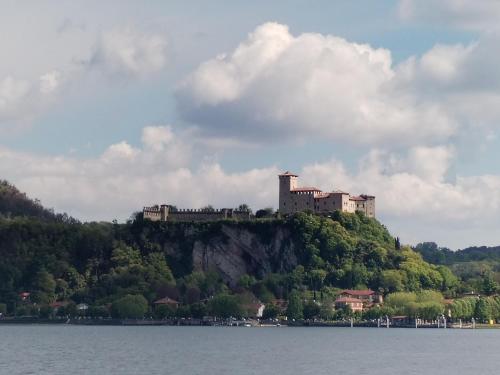 a castle on top of a hill on the water at BnB Ranco in Ranco
