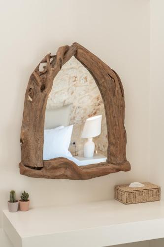 a mirror with a wooden frame on a shelf at NEW LUXURY STONE Villa AMENTE in Fiskardho